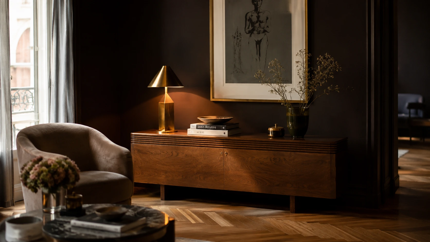 Contemporary interior pairing deep espresso brown walls with 1920s streamlined furniture and warm brass lighting.